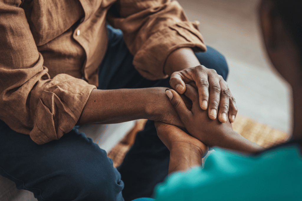 Closeup of a support hands. Closeup shot of a young woman holding a senior man's hands in comfort. Female carer holding hands of senior man.