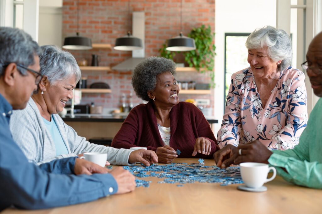 Group of diverse senior male and female friends doing puzzles at home. socializing with friends at home.
