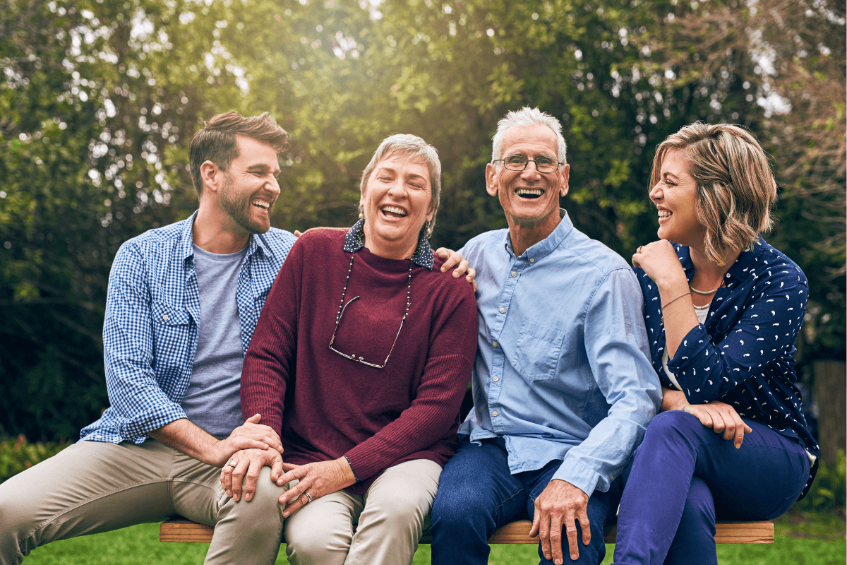 Senior couple accompanied by their family in an outdoor portrait with hug, vacation and support in relationship connection.