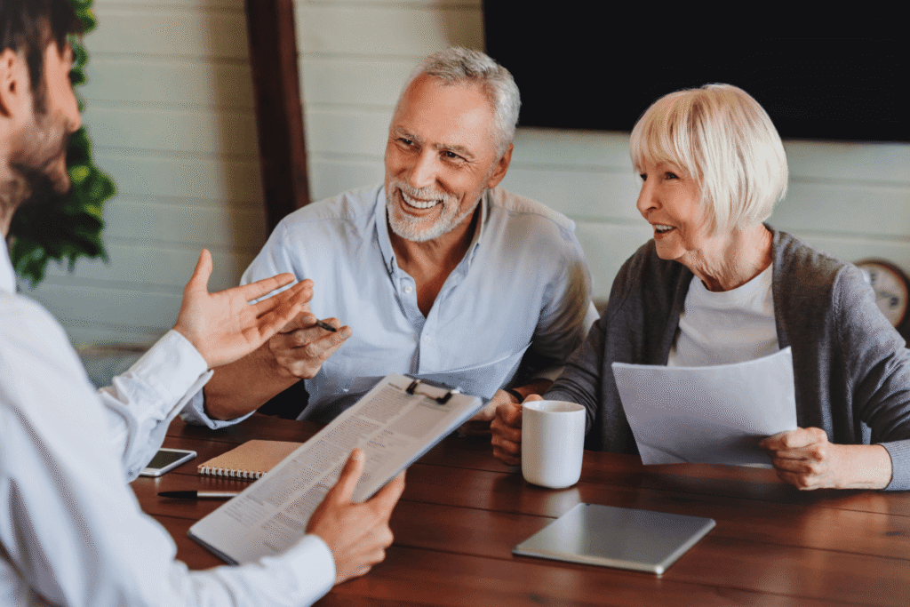 Happy mature family couple of clients consulting legal expert, lawyer, solicitor about legal document signing, asking advice.