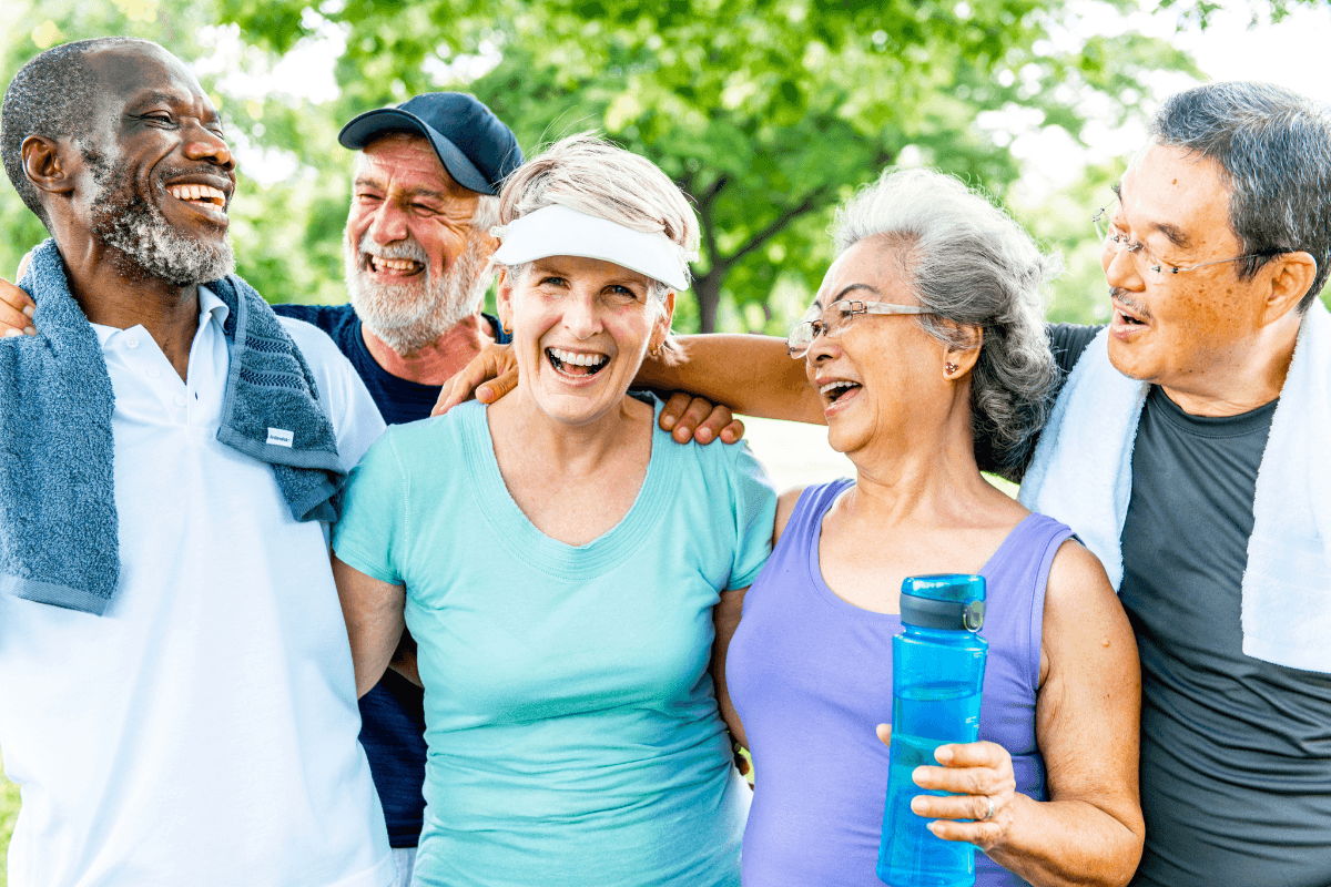 Group of healthy diverse seniors smiling outdoors, enjoying exercise on a sunny day.